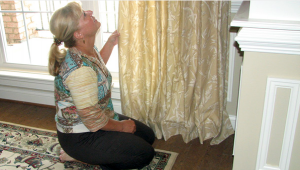 Woman Adjusting Curtain